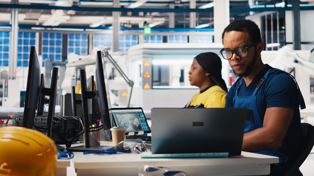 black engineer inputs solar system parameters at industrial workstation